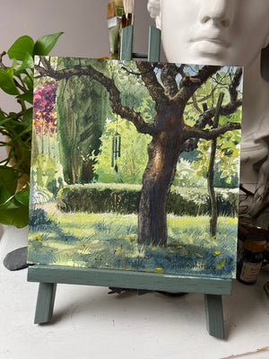 Beneath the Old Tree on a studio easel, showing the complete unframed 20 × 20 cm watercolour.