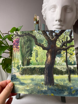 Beneath the Old Tree held by hand, showing the original unframed square watercolour on paper.