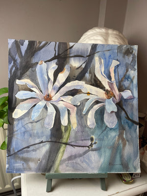 Magnolia in Soft Light on a studio easel, showing the complete unframed 40 × 40 cm watercolour.