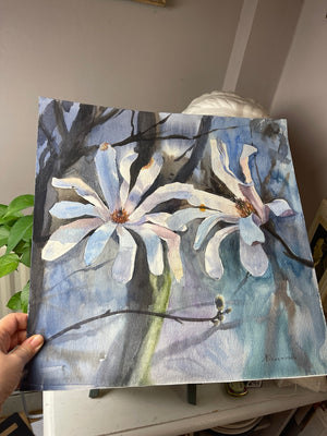 Magnolia in Soft Light held by hand, showing the original unframed square watercolour on paper.