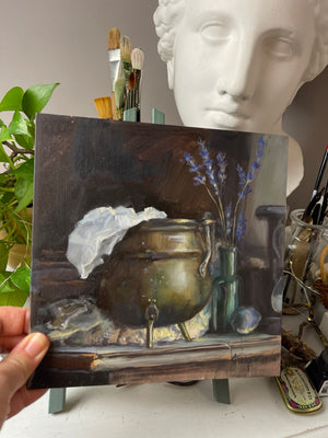 Brass and Lavender held by hand, showing the original unframed 20 × 20 cm oil painting.